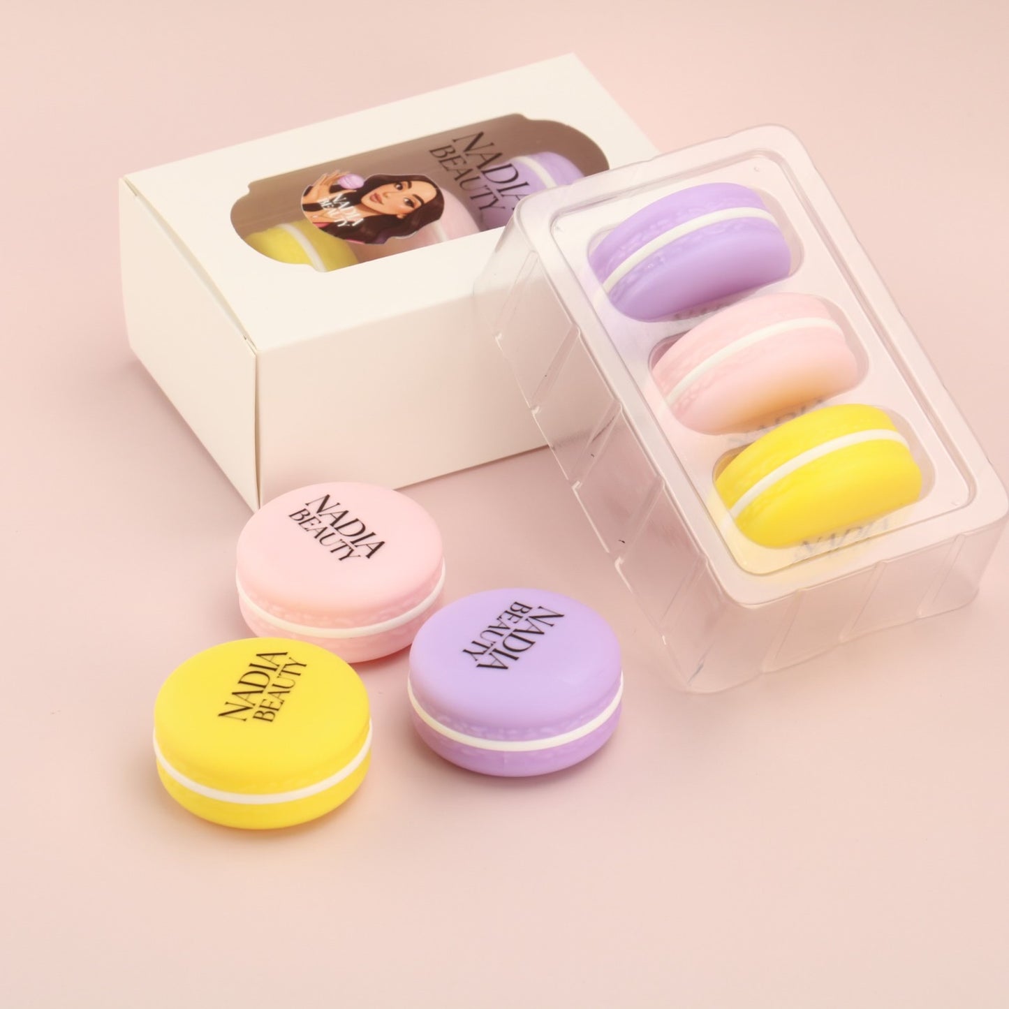 Colorful macaron-shaped containers with 'Nadia Beauty' branding on a pink background
